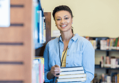 woman holding stack of books